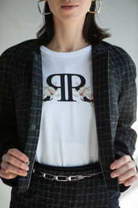 Tee-shirt blanc imprimé logo porté sous un blazer avec jupe élégante